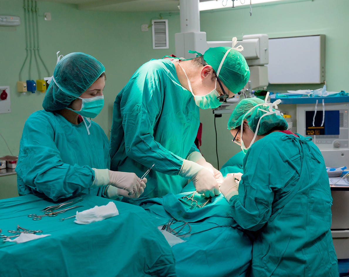 Doctors and nurses in scrubs performing surgery in an operating room